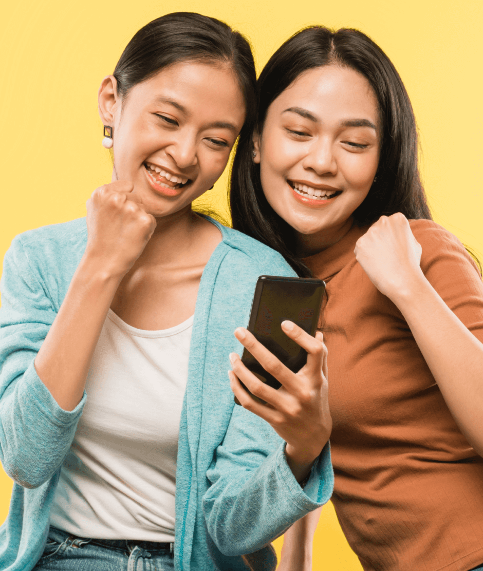 two-young-woman-happy-with-hands-clenched-when-looking-mobile-phone-screen 1 (1)